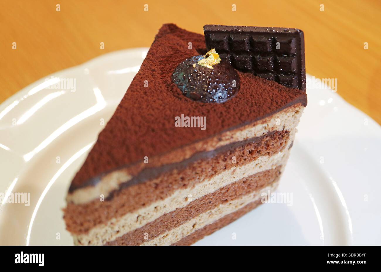 Primo piano una fetta di gustosa torta al cioccolato in chiffon su un piatto bianco Foto Stock