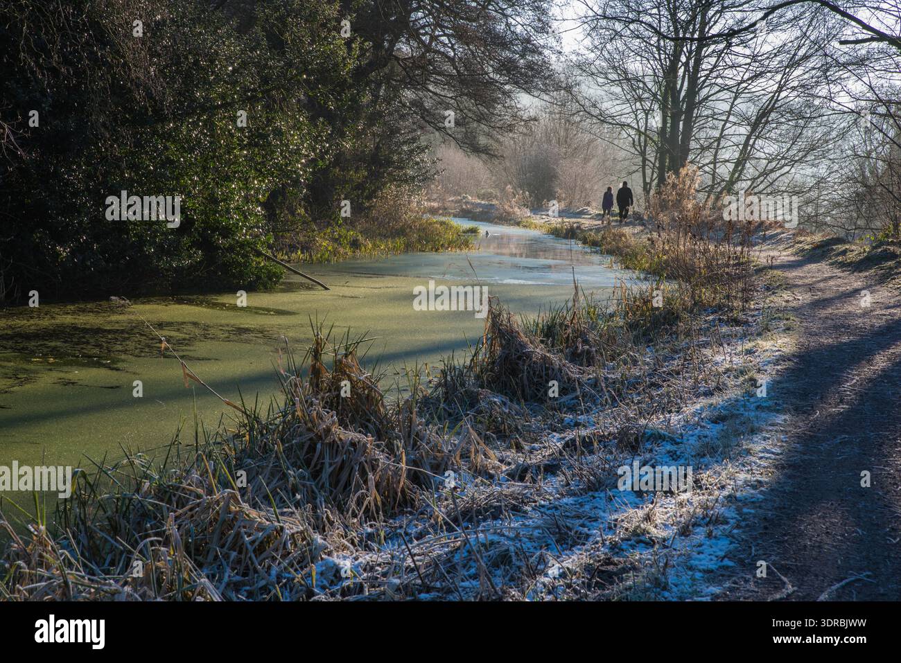 Una coppia fa una passeggiata lungo il sentiero cittadino del canale cromford, vicino a Whatstandwell, Derbyshire, in Inghilterra, in una fredda mattina ghiacciata Foto Stock