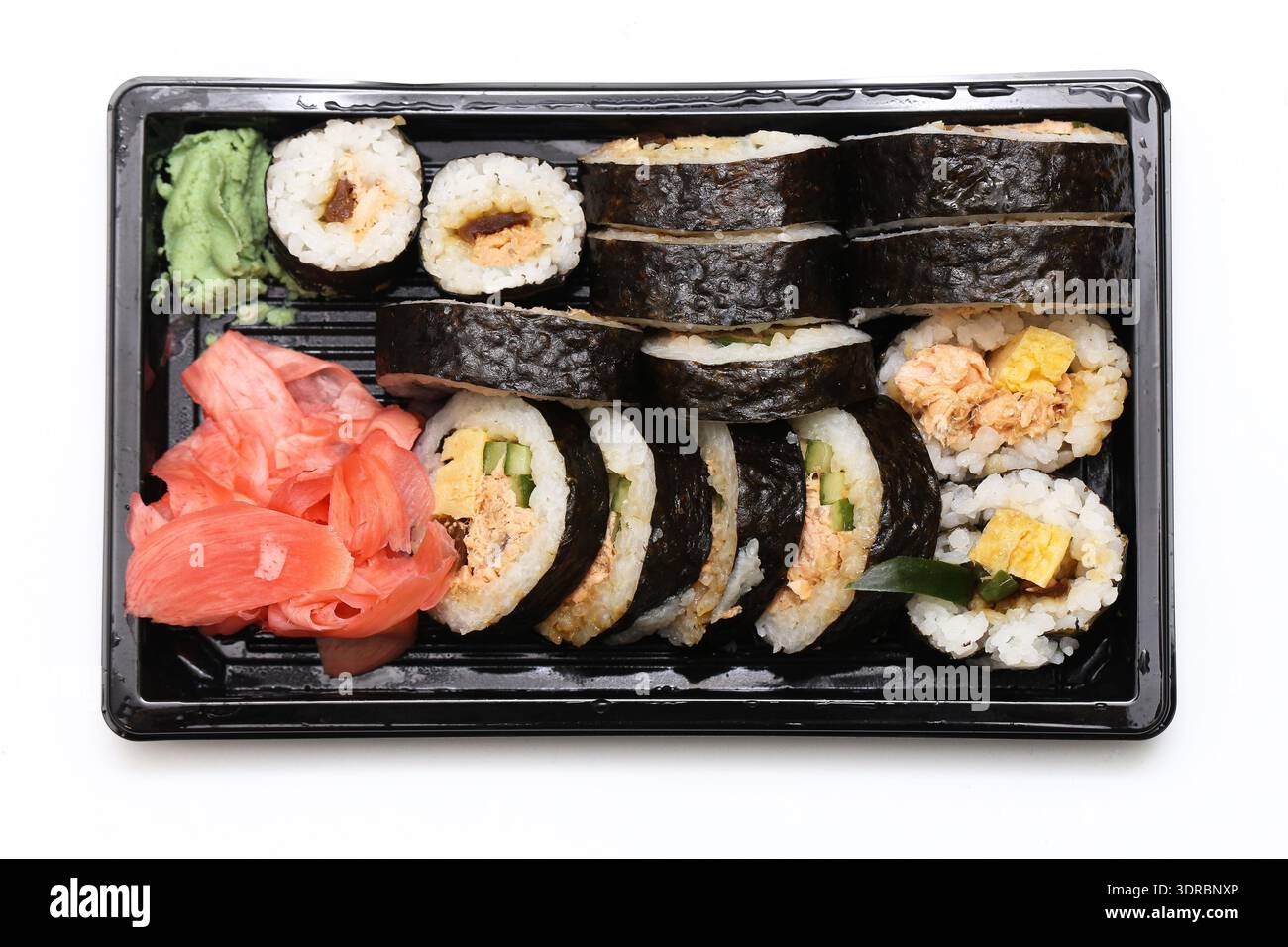Panini di sushi in un contenitore da asporto. Assortimento di piatti giapponesi con zenzero e wasabi. Cucina asiatica fresca. Foto Stock