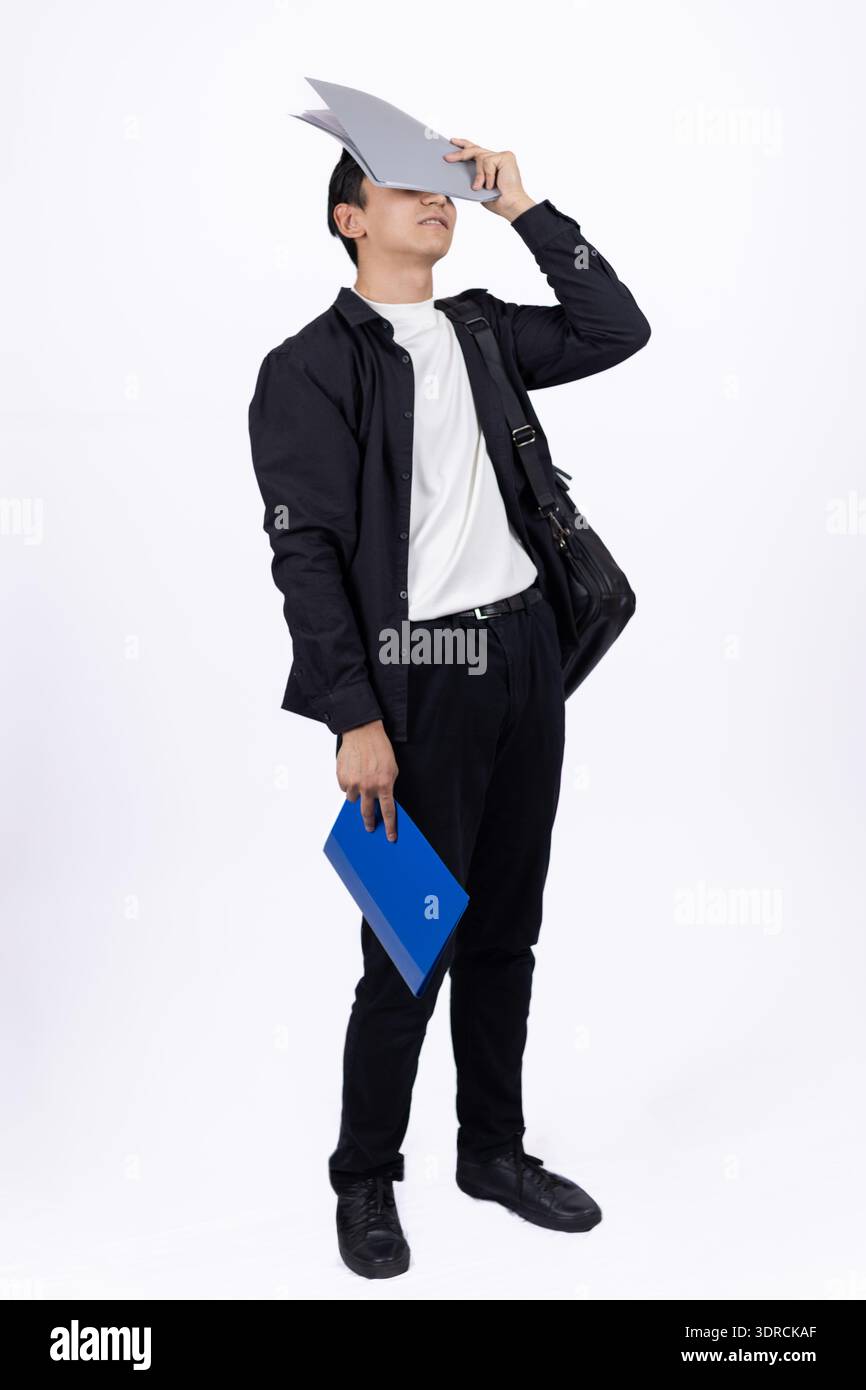 Uomo in tuta nera con diploma su sfondo bianco Foto Stock