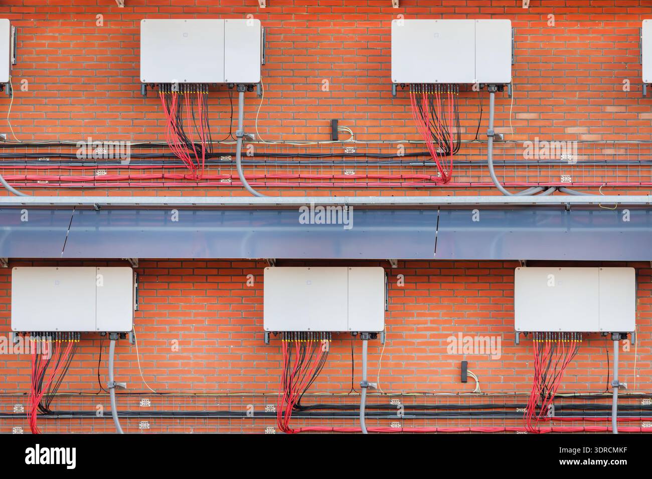 Ampia gamma di inverter per pannelli solari su una parete di fabbrica Foto Stock