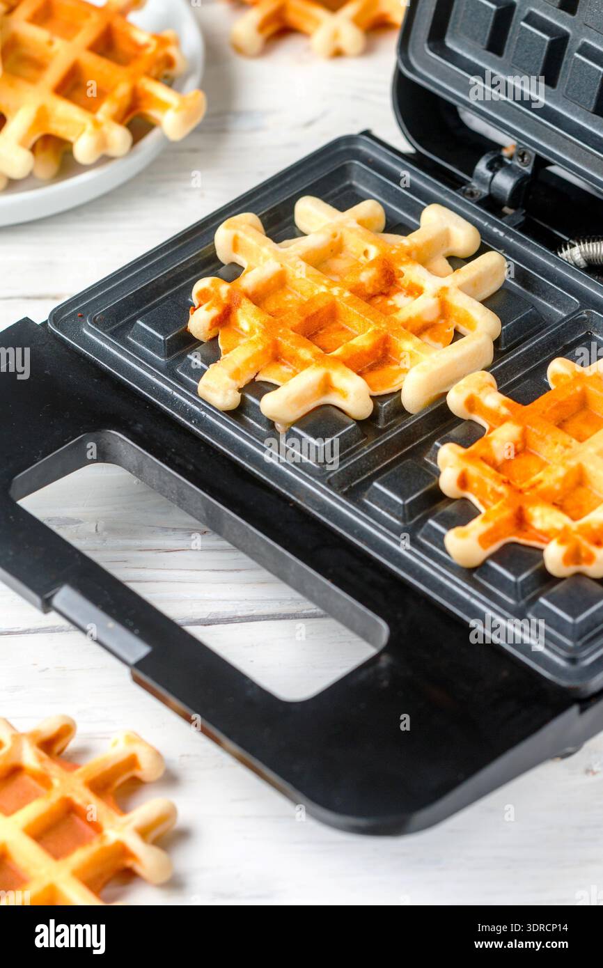 Preparazione di waffle fatti in casa. Ferro da stiro in cucina. Messa a fuoco selettiva Foto Stock
