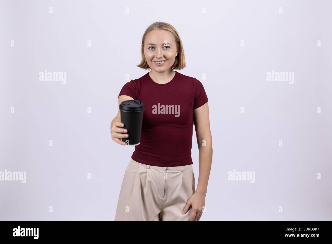 Donna sorridente in t-shirt scura che tiene in mano una macchina fotografica in studio Foto Stock