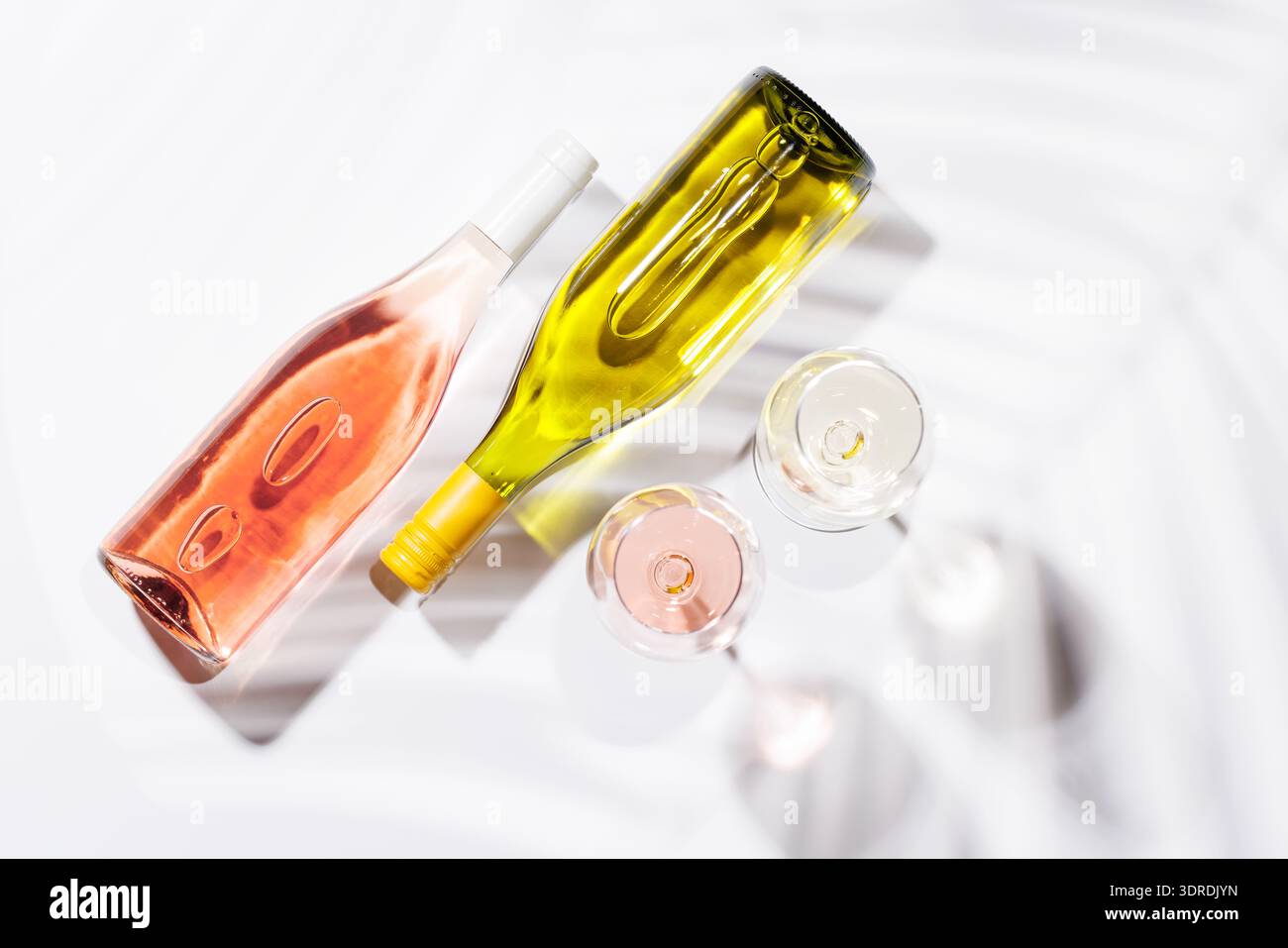 Due bicchieri da vino pieni di rosa e vino bianco Foto Stock