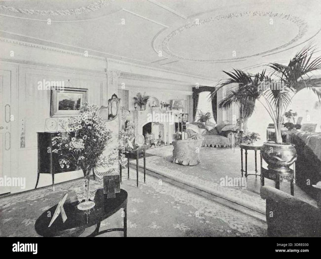 Questa immagine raffigura il salotto di Lanfine, Ayrshire, catturato da James Kennedy Hunter nel 1914. La sala presenta elementi di design degli interni edoardiani, tra cui modanature ornate, soffitti alti, caminetti decorativi, pannelli in legno, grandi finestre, e mobili d'epoca disposti simmetricamente. L'attenzione è data alle luci, ai rivestimenti e ai dettagli architettonici, che riflettono lo stile delle case di campagna scozzesi del XX secolo e l'artigianato nella decorazione degli interni. Foto Stock