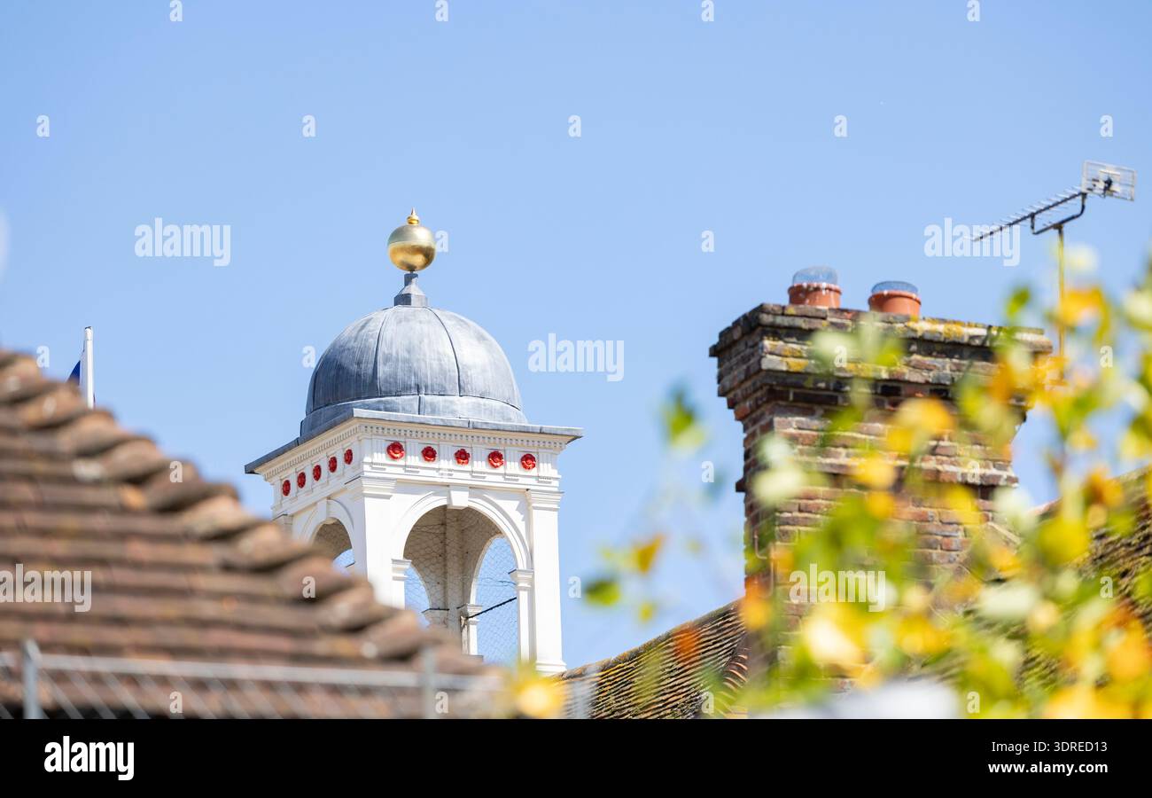Storica cupola sul tetto con cupola e oro vicino a Brick Chimney sotto Clear Blue Sky Foto Stock