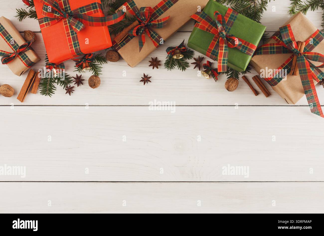 Regali disposti su una superficie in legno con decorazioni natalizie e spezie per un look festivo Foto Stock