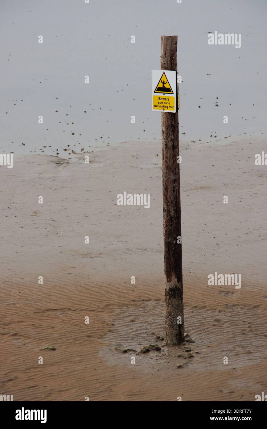 Pericolo di affondamento di fango sul palo nella sabbia della spiaggia durante la bassa marea Foto Stock