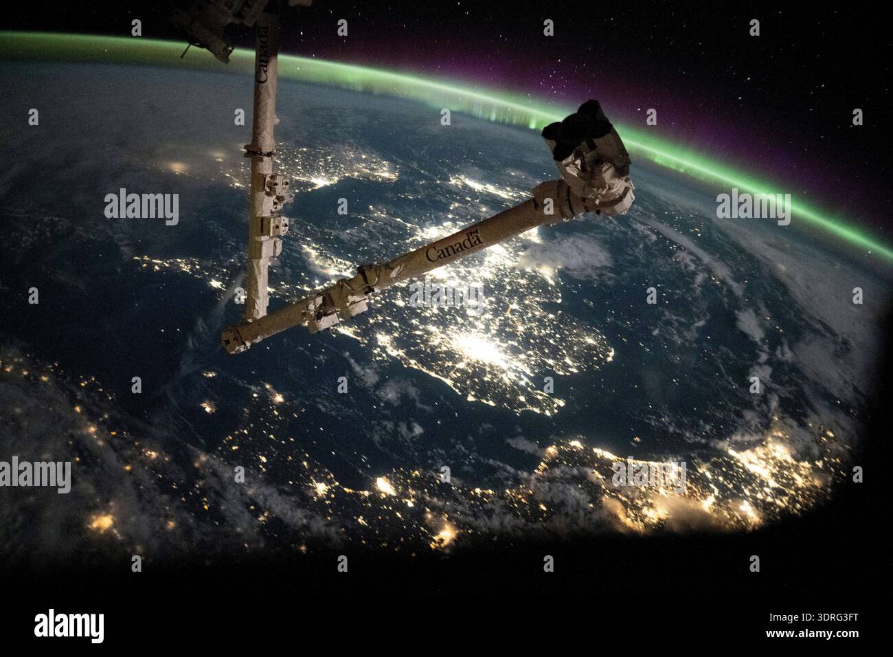 Il Canale della Manica separa le coste della Francia e dell'Inghilterra sotto un'aurora che incorona l'atmosfera terrestre. Le vaste luci della città di Londra sono visibili al centro, mentre le città costiere del nord Europa, inclusa Amsterdam, possono essere viste in alto a sinistra. In primo piano, c'è il braccio robotico Canadarm2. La stazione spaziale Internazionale stava orbitando a 263 miglia sopra la Francia alle 23:38 ora locale, quando questa fotografia è stata scattata Una fotografia scattata dalla stazione spaziale Internazionale il 13 settembre 2025. Una versione ottimizzata di un'immagine ISS originale: Credito: NASA/JAXA. Solo per uso editoriale Foto Stock