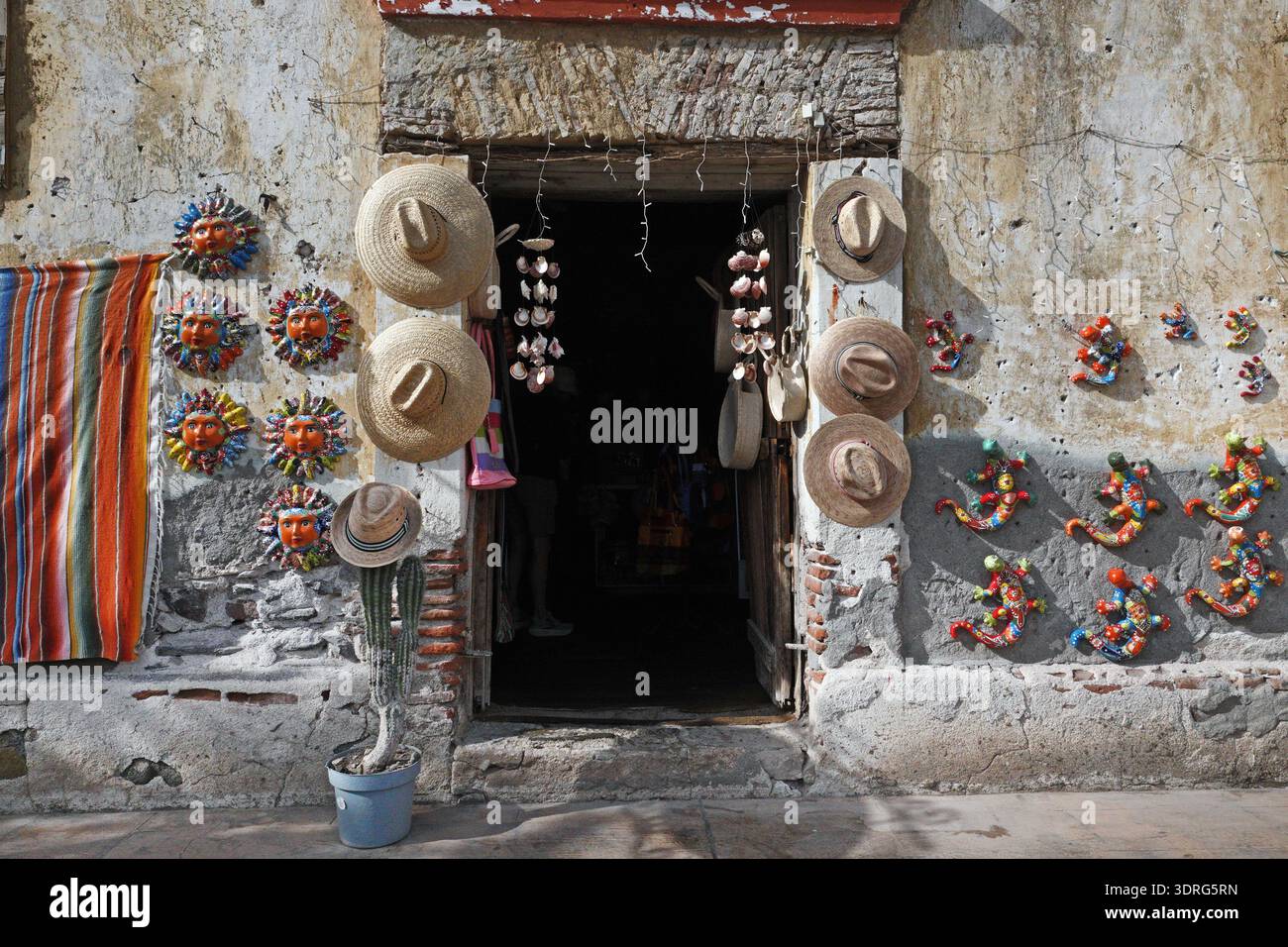 Un serape messicano, sombrero e artigianato indiano decorano la porta di un negozio nella piazza di Loreto, Baja, Messico. Foto Stock