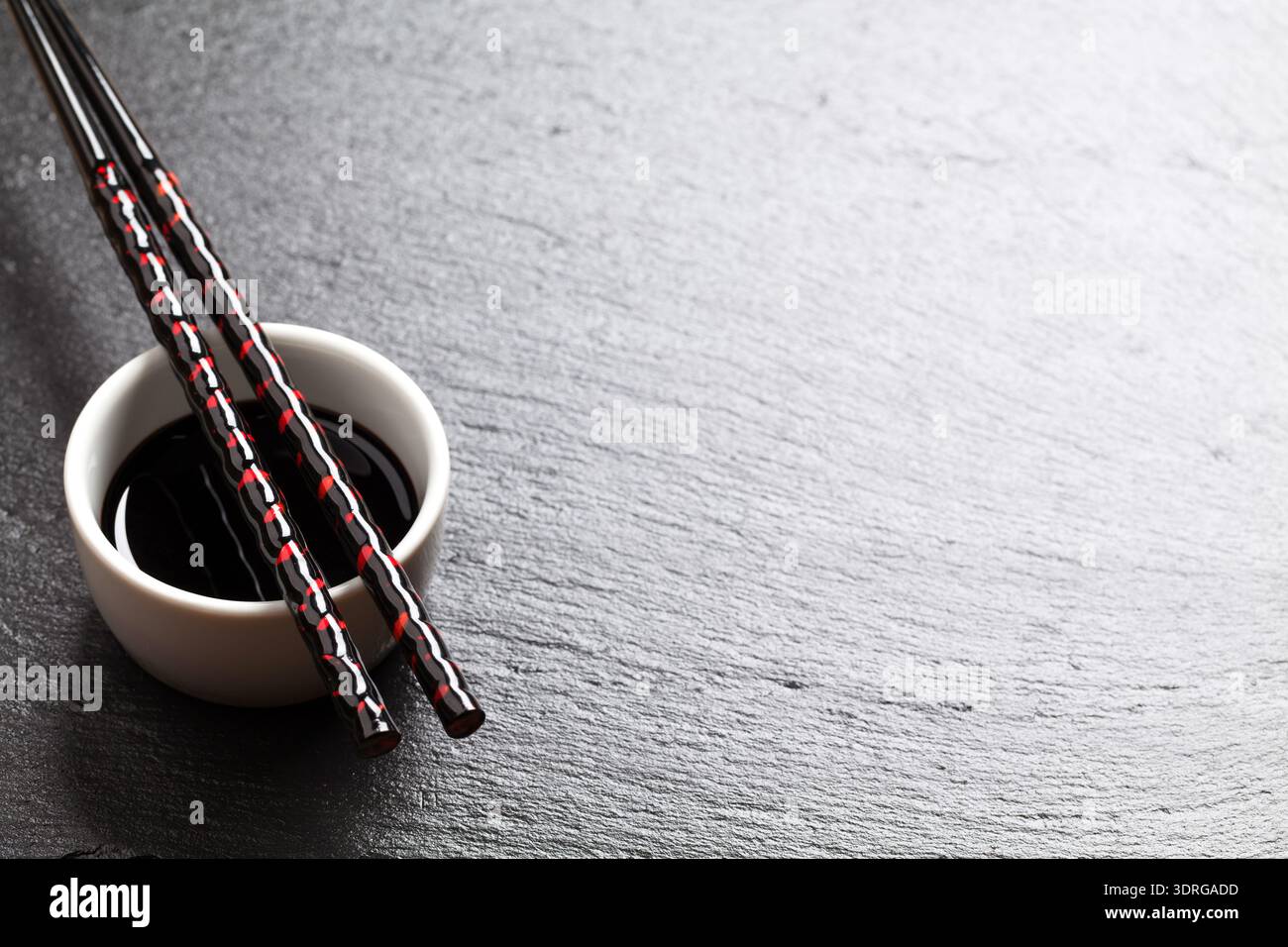 Bacchette di sushi giapponesi sopra la ciotola della salsa di soia Foto Stock