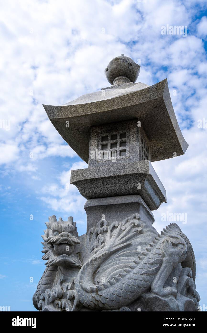 Lanterna in pietra intagliata con drago - Toro - nell'isola di Enoshima, Giappone Foto Stock