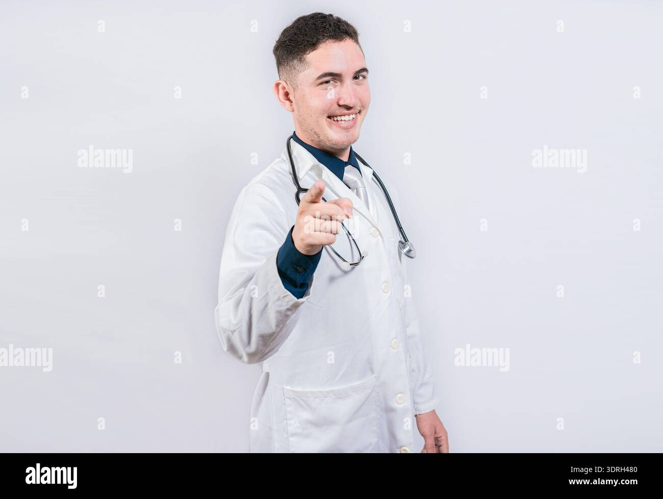 Bel medico che punta verso la telecamera. Medico cordiale e sorridente che ti indica, giovane medico che ti indica Foto Stock