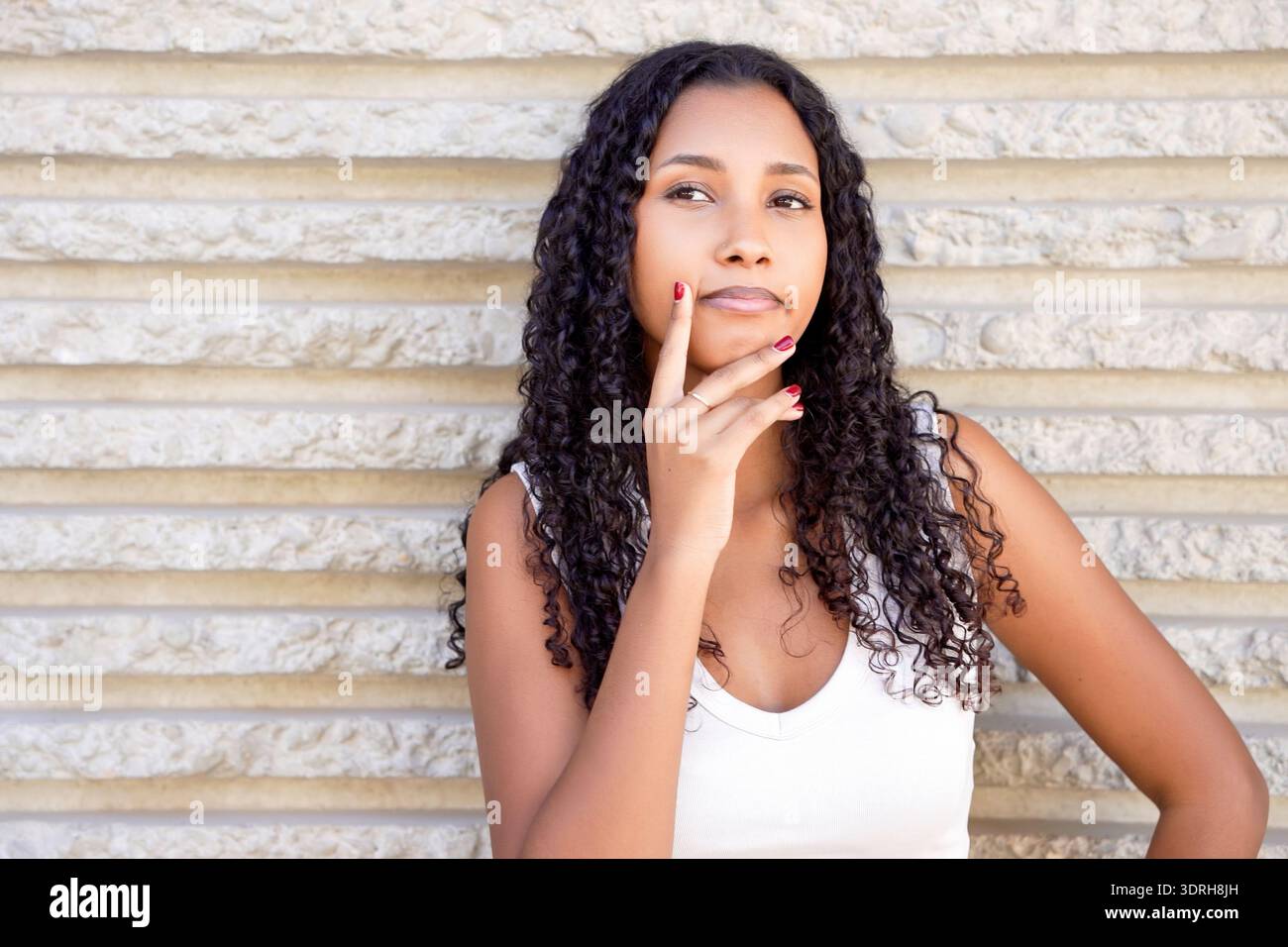 Il modello ritrae la fiducia rilassata in un ambiente con luce soffusa con texture naturali ed espressioni delicate Foto Stock