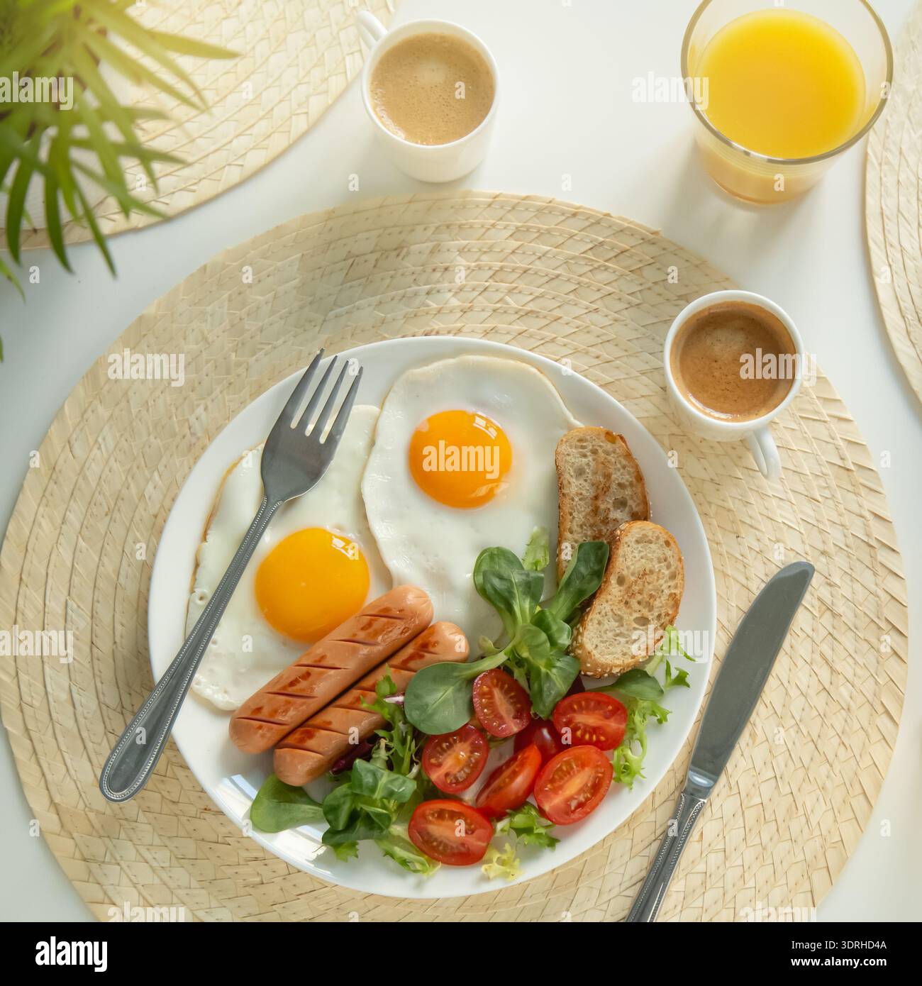 Colazione al mattino, salsicce, fritti, insalata di pane e verdure, tazza di caffè, bicchiere di succo d'arancia. Tavolo bianco, Foto Stock