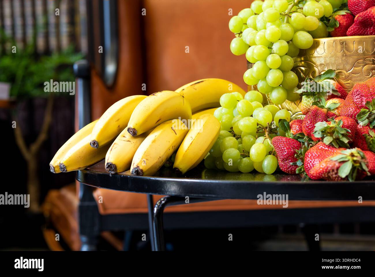 Tavolo con frutta fresca, uva verde, banane e fragole Foto Stock