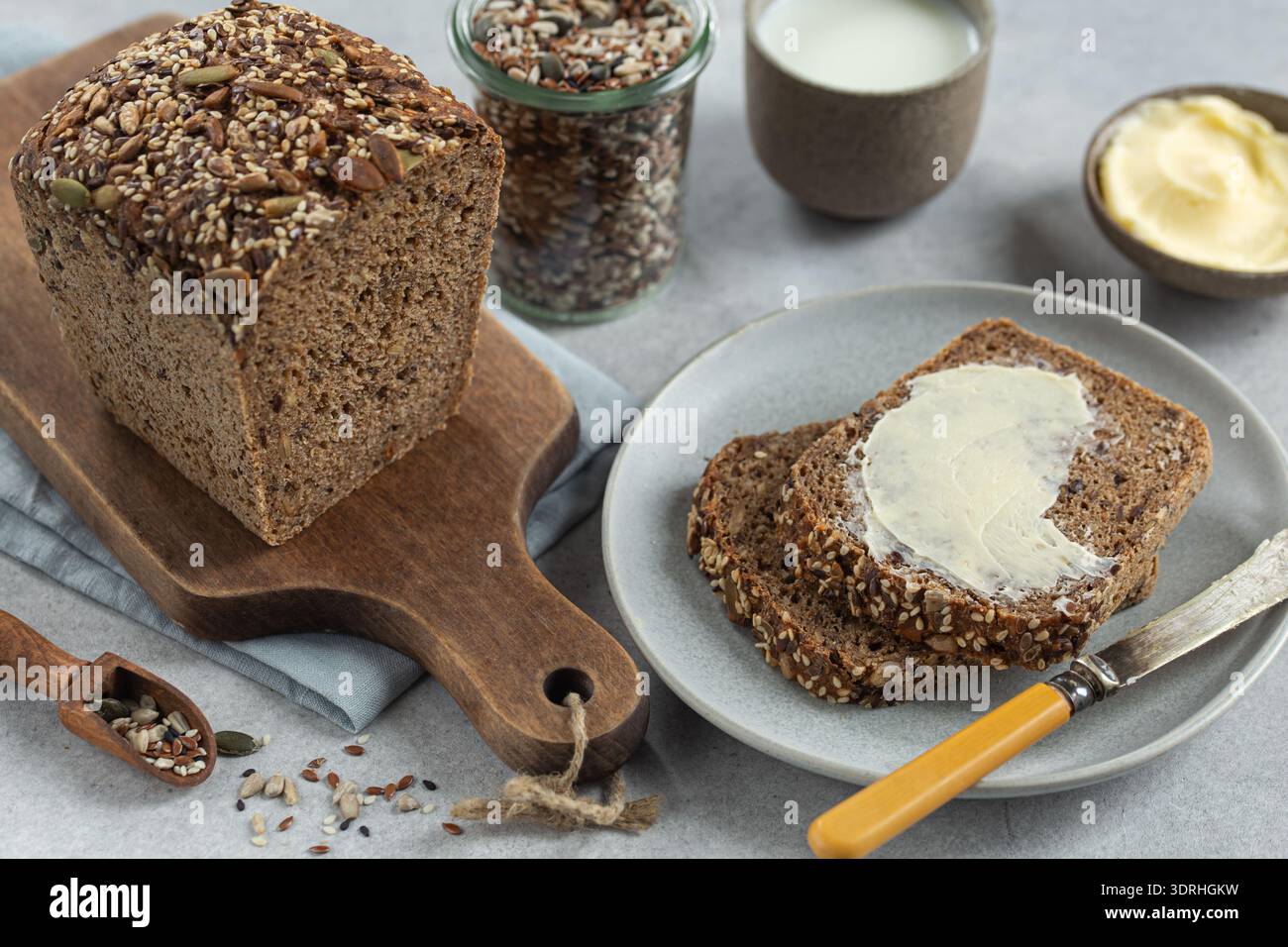 Pane fatto in casa con impasto multigrano e burro appena sfornato Foto Stock