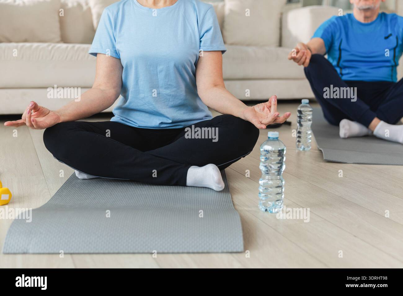 Meditazione sulla consapevolezza dello yoga. Coppia matura senior che pratica yoga a casa. Mani nel mento mudra gesto. Vecchio marito moglie seduta Foto Stock