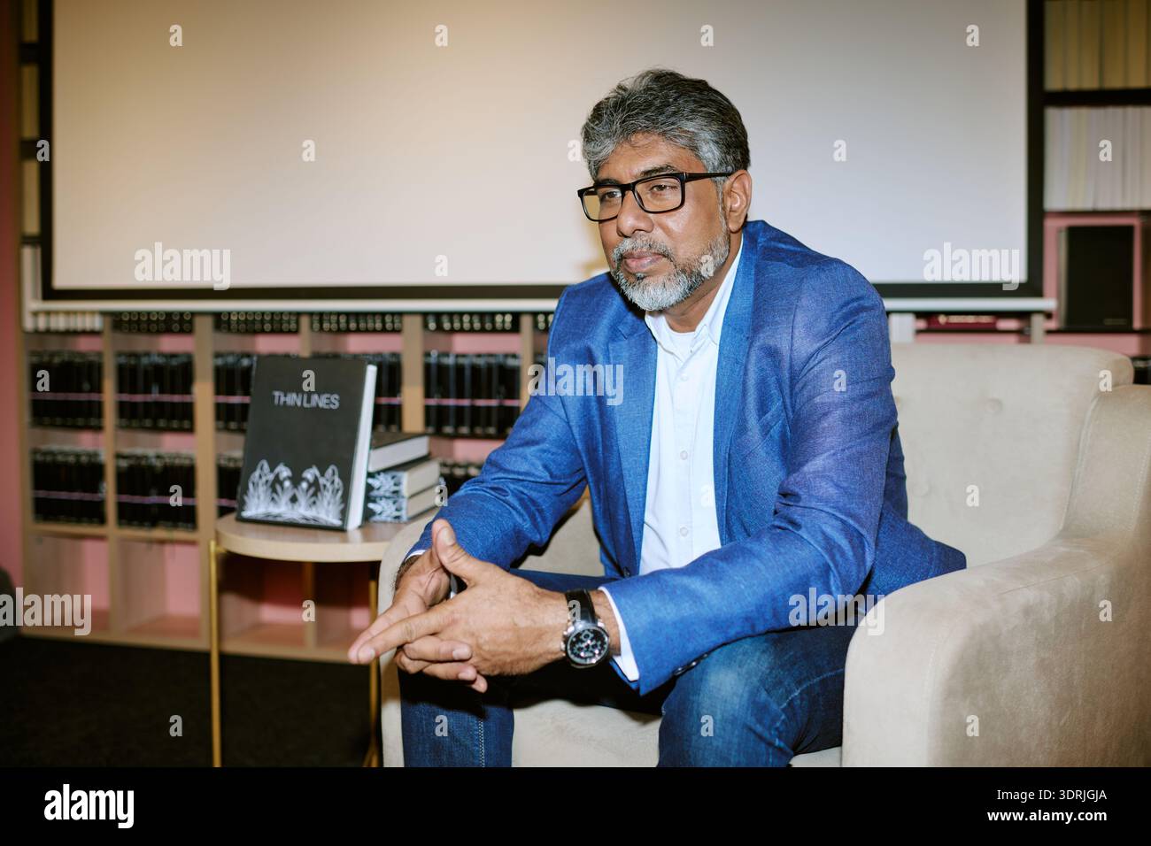 Ritratto dell'uomo di mezza età seduto durante l'evento di presentazione del libro Foto Stock