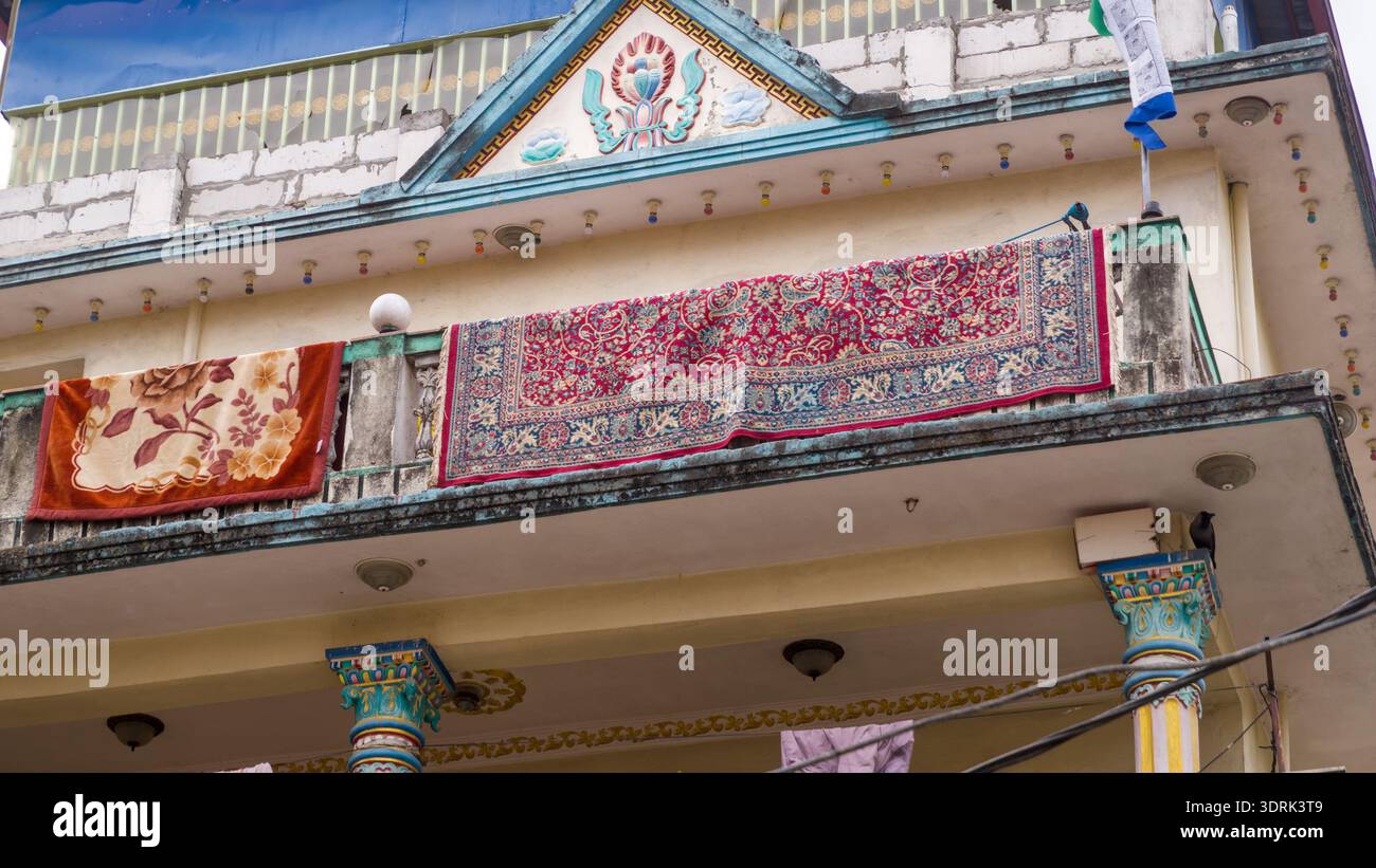 Tappeti tradizionali appesi su un balcone decorato di un edificio. Foto Stock