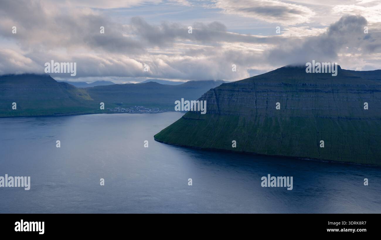 Le maestose scogliere costiere delle Isole Faroe riflettono la tranquillità alla luce del mattino Foto Stock