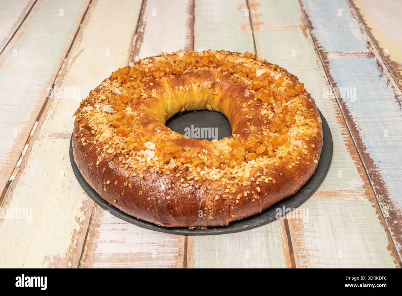 Un dettaglio della crosta: Primi piani di mandorle tostate, spolverini di zucchero e pezzi di frutta candita che aderiscono all'oro Foto Stock