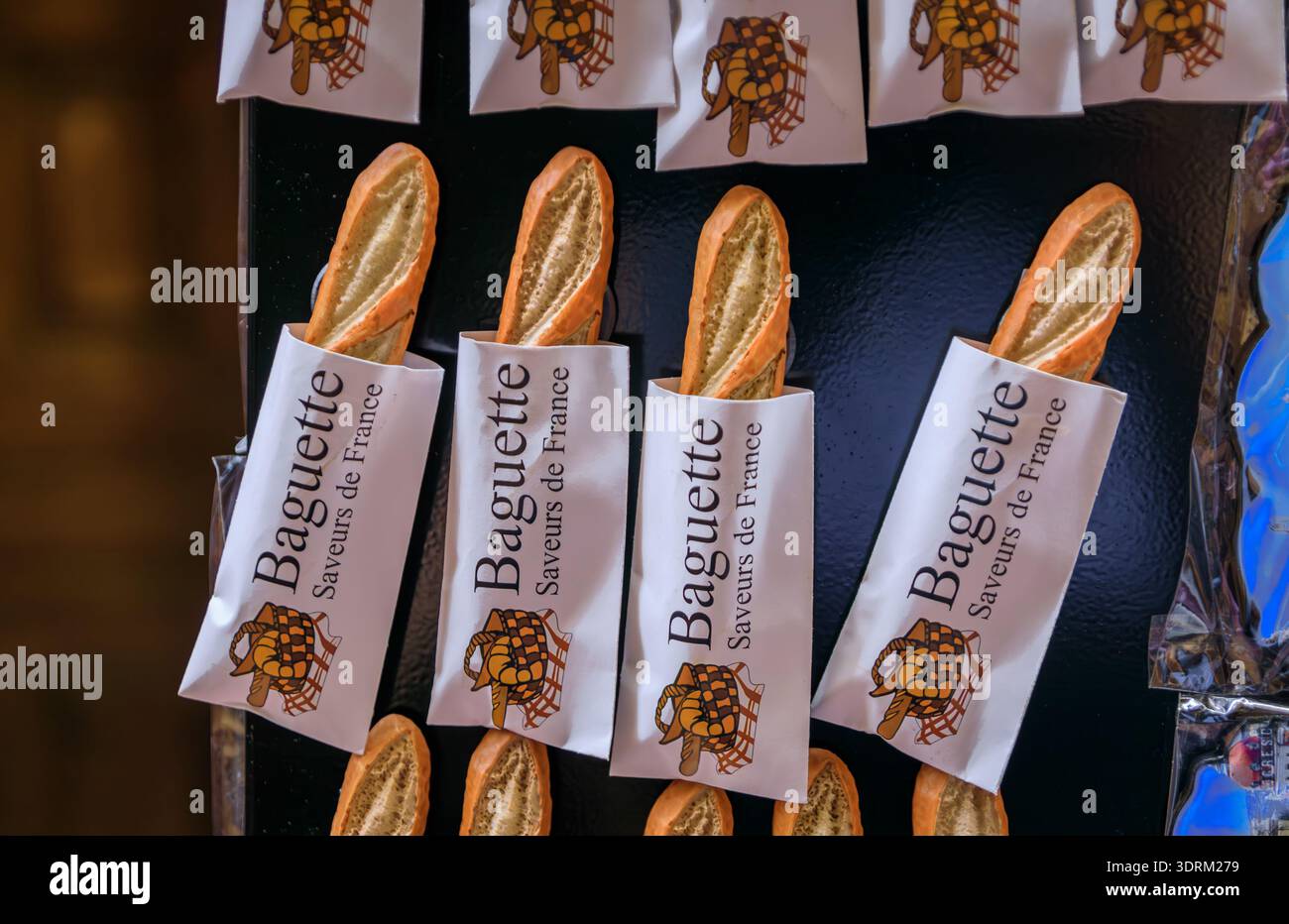 I magneti per frigorifero a forma di tradizionale baguette francesi in maniche di carta bianca sono esposti in un negozio di souvenir nella città vecchia di Nizza, in Francia Foto Stock