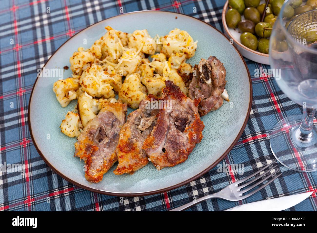 Contorni di cavolfiore di agnello e verdure grassi e succosi fritti con vino e olive Foto Stock