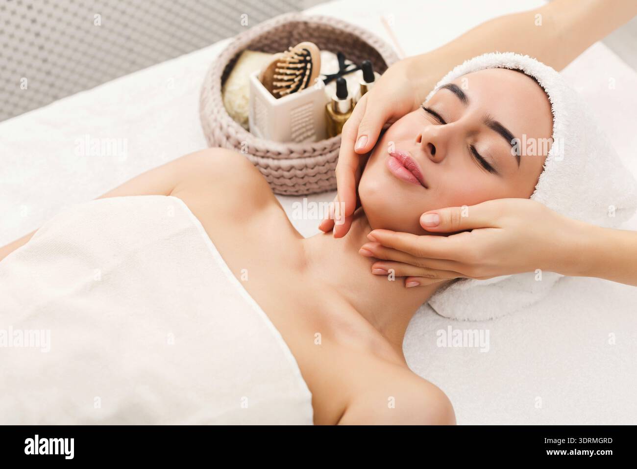 La donna riceve un trattamento viso nella Spa con luce soffusa e atmosfera rilassante Foto Stock