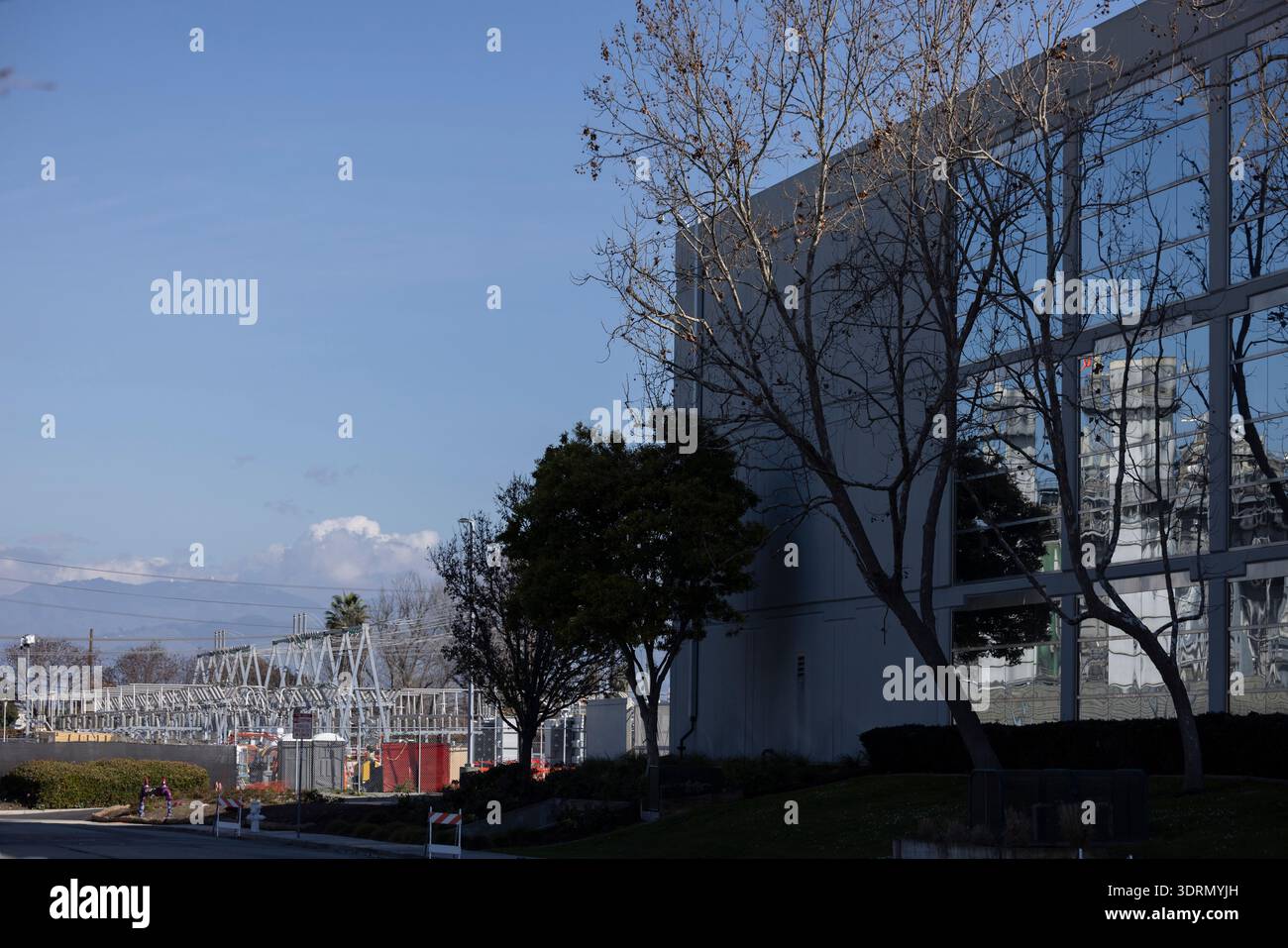 Una centrale elettrica si riflette in una finestra del data center, mentre una sottocentrale elettrica fornisce energia tramite linea elettrica a un data center a Santa Clara, California, Stati Uniti Foto Stock