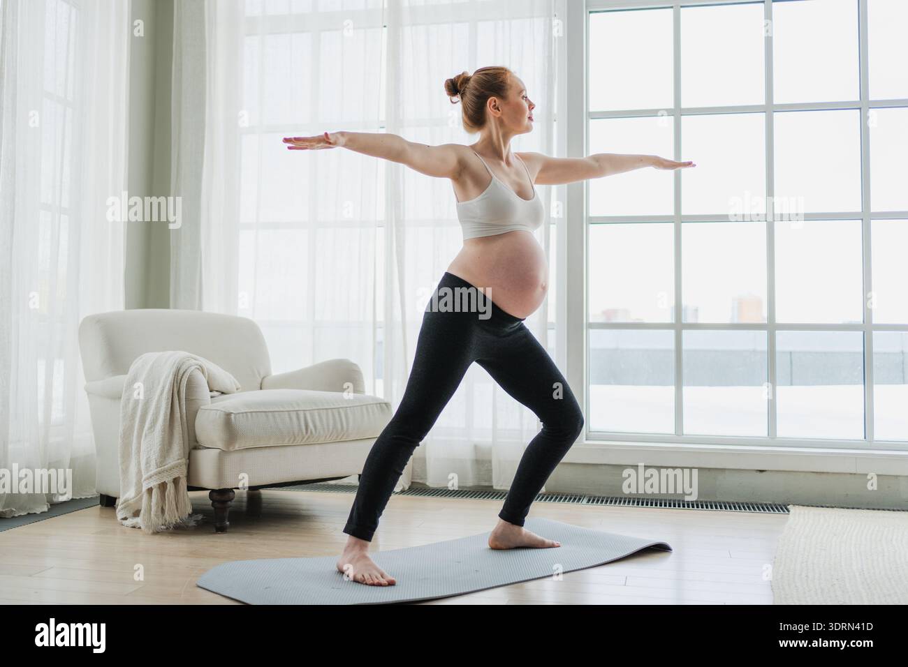 Allenamento fitness yoga gravidanza. Donna incinta che pratica yoga a casa. Ragazza incinta che fa esercizio sportivo sul tappetino da yoga Foto Stock