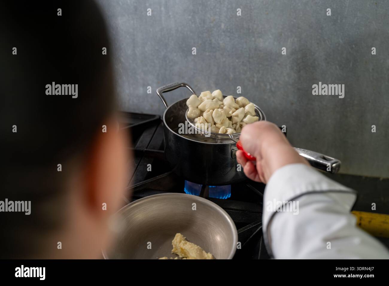 Primo piano del manti bollito che viene sollevato dalla pentola. Foto Stock