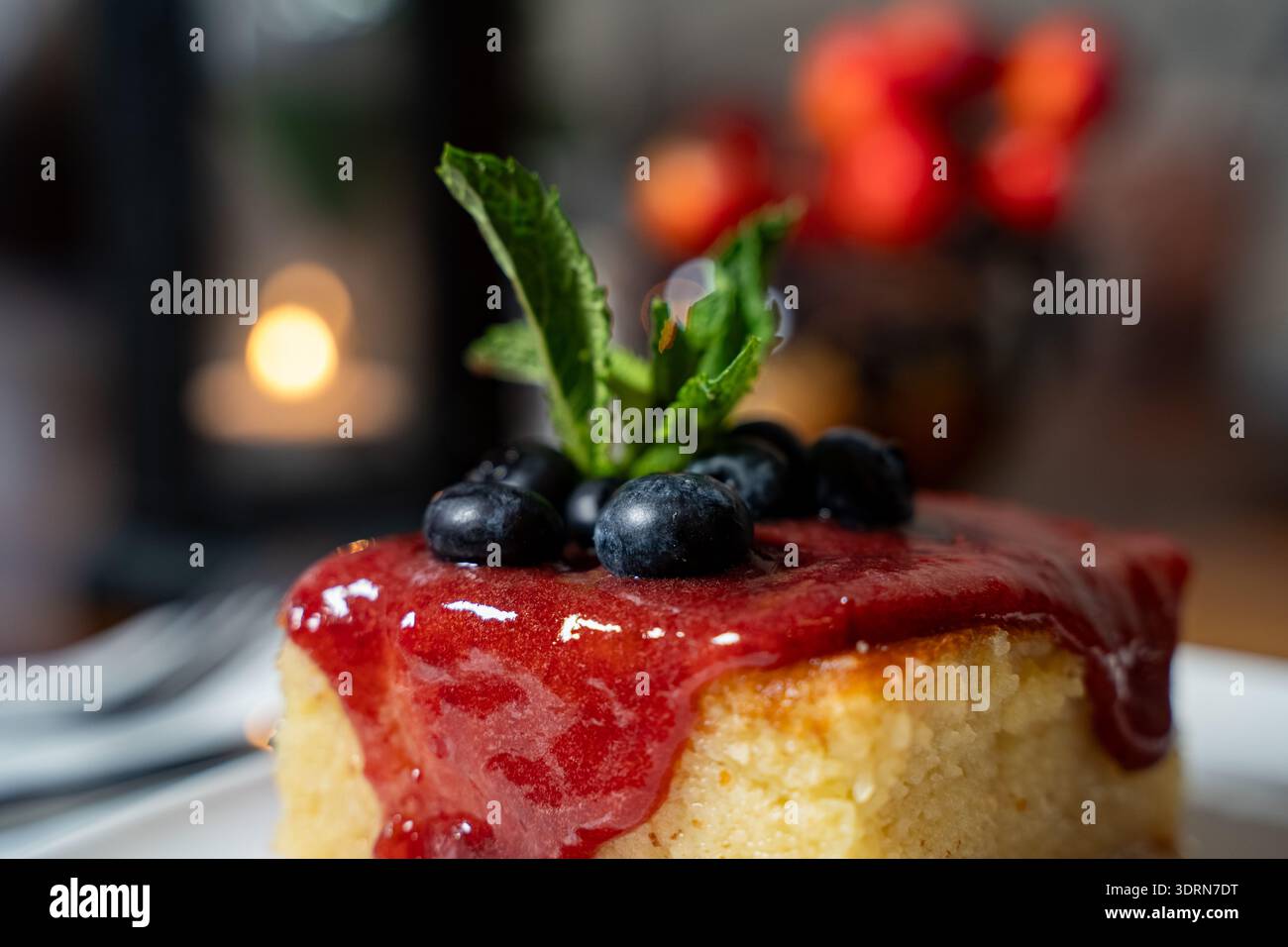 Primo piano della torta di semola con salsa di fragole e mirtilli. Foto Stock