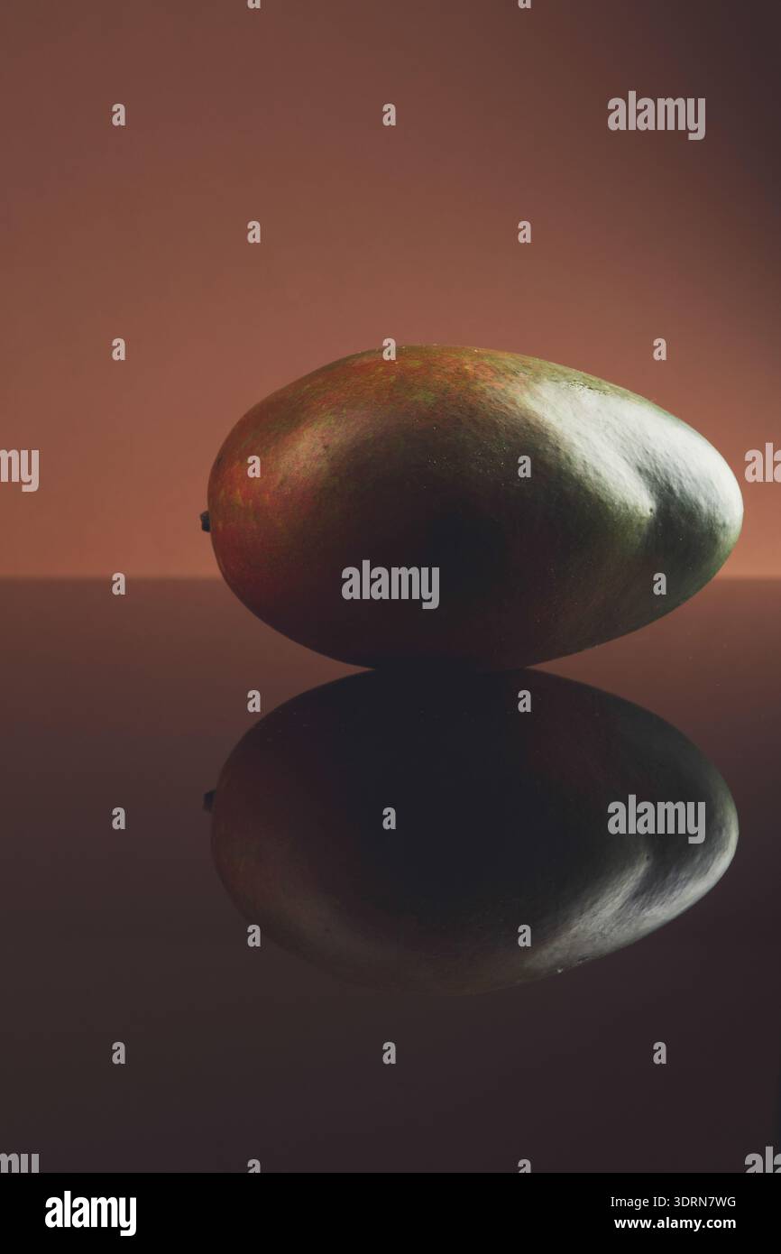 Mango maturo su sfondo in vetro scuro con riflesso Foto Stock