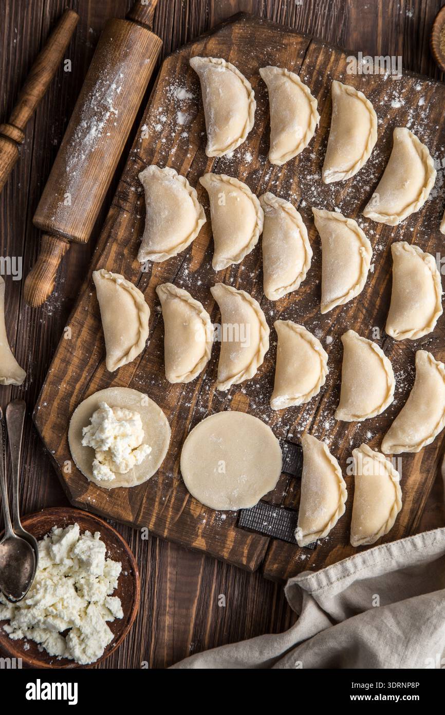 Gnocchi di formaggio cottage crudi fatti in casa su sfondo di legno Foto Stock