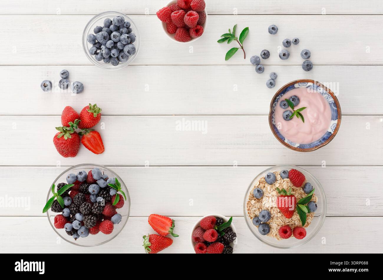 Frutta fresca e yogurt in una disposizione collage su un tavolo di legno Foto Stock