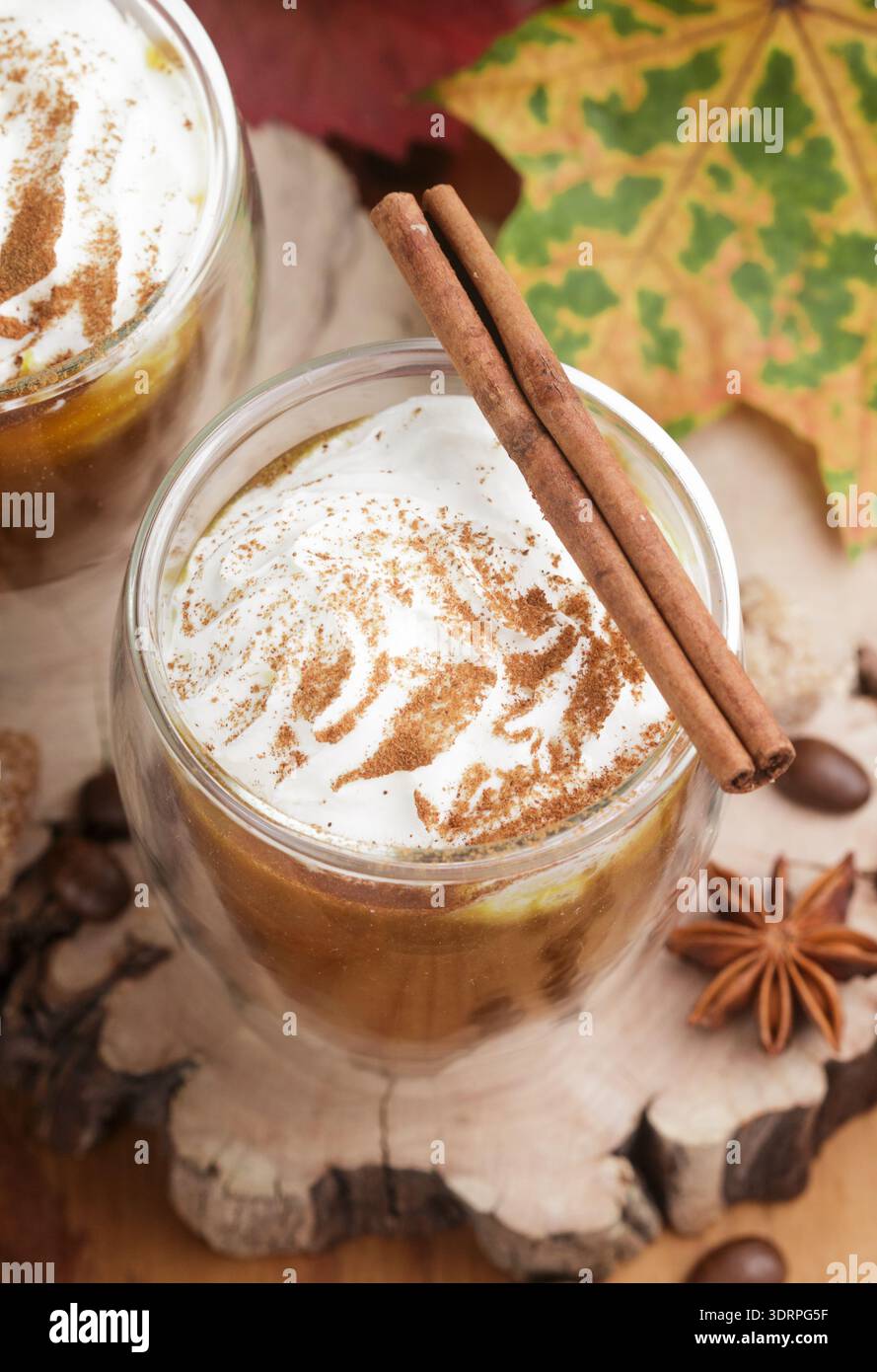 Latte macchiato di zucca o frullati con panna e spezie-cannella, anice stellato, caffè. A freddo o a caldo rientrano bere. Messa a fuoco selettiva Foto Stock