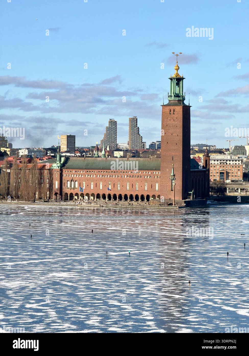 Il municipio di Stoccolma (Stadshuset) e la sua torre iconica accanto al lago ghiacciato Mälaren durante l'inverno, Stoccolma, Svezia. - Immagine stock catturata con smartphone