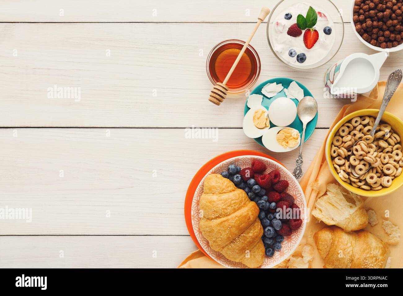 Colazione con vari cibi su un tavolo di legno chiaro al mattino Foto Stock