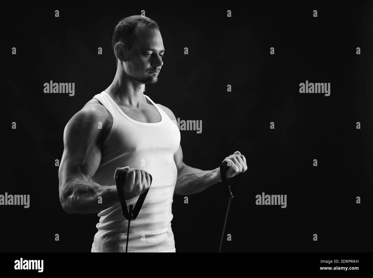 Allenamento per il bodybuilding con fasce di resistenza in un ambiente da studio durante la sessione di allenamento al coperto Foto Stock