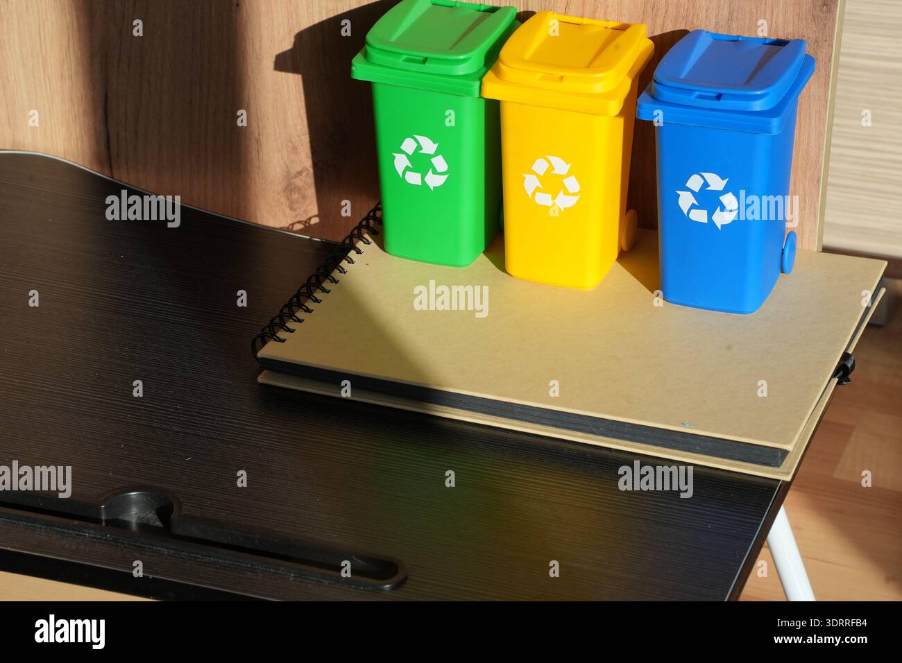 Contenitori di riciclo colorati sulla scrivania che simboleggiano lo stile di vita a rifiuti zero uffici sostenibili consapevolezza del clima responsabilità aziendale ESG e ambiente moderno Foto Stock
