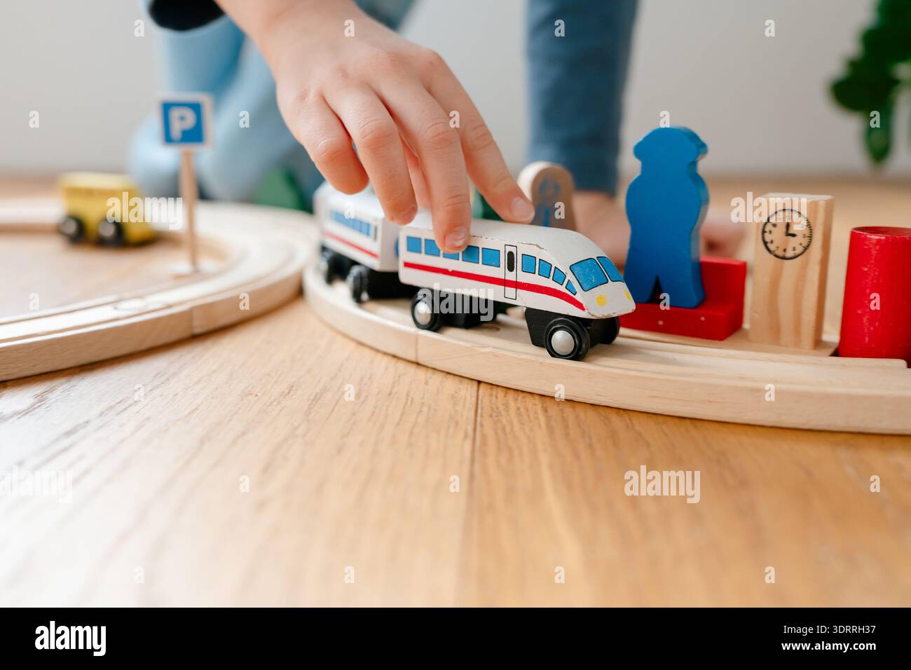Primo piano del treno giocattolo in legno in pista. Giocattolo educativo ecologico realizzato con materiali naturali. Concetto di prodotti per bambini sostenibili e creativi Foto Stock