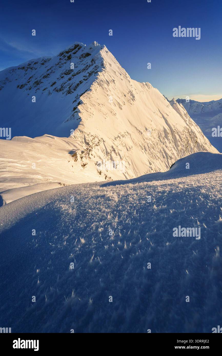 Vista aerea delle montagne innevate sotto un cielo azzurro e cristallino, le cime bianche che contrastano con le ombre profonde, Valdez, Alaska, Stati Uniti Foto Stock