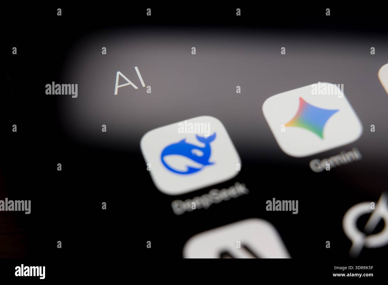 Icone delle applicazioni DeepSeek e Gemini visualizzate sullo schermo di uno smartphone all'interno di una cartella ai, che rappresentano il panorama competitivo dell'artificia mobile Foto Stock