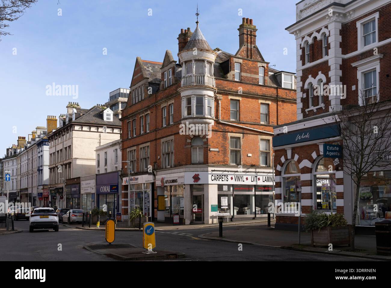 Le auto passano accanto ai negozi di Cheriton Place, Folkestone, Kent. Foto Stock