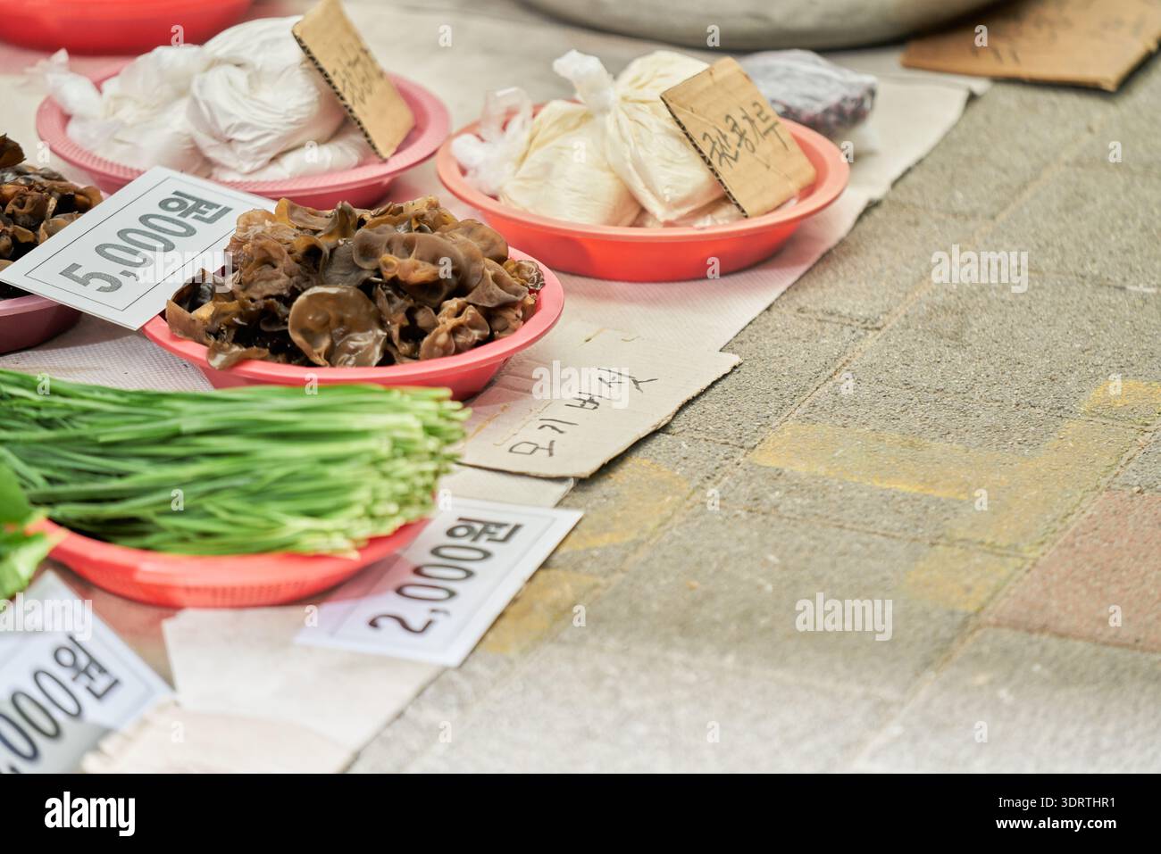 Mercato di 5 giorni di Yecheon a fine primavera, Corea del Sud. I venditori vendono cipolle fresche, verdure di stagione e torte di riso fatte a mano alla gente del posto. Foto Stock
