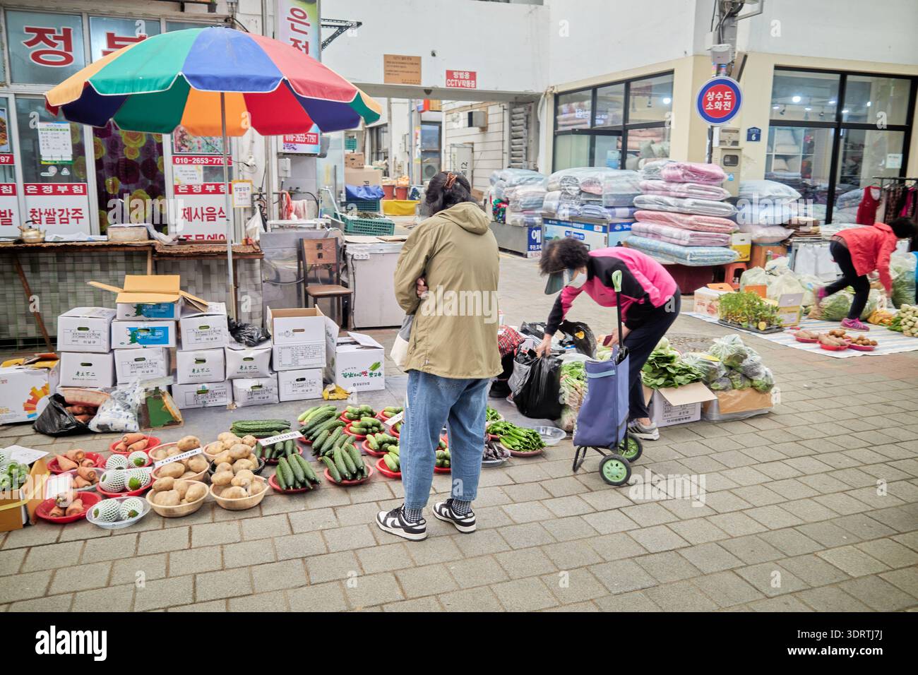Mercato di 5 giorni di Yecheon a fine primavera, Corea del Sud. I venditori vendono cipolle fresche, verdure di stagione e torte di riso fatte a mano alla gente del posto. Foto Stock