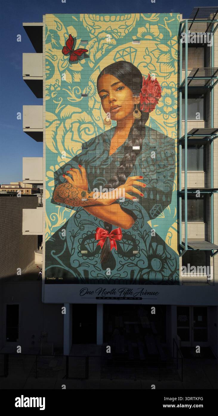 Tucson, Stati Uniti - 21 aprile 2025: Veduta aerea di un vivace murale sul lato di un edificio moderno, caratterizzato da un ritratto con un fiore rosso e ma Foto Stock