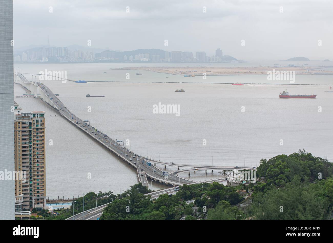 Un moderno ponte a più corsie trasporta il traffico attraverso un ampio fiume Foto Stock