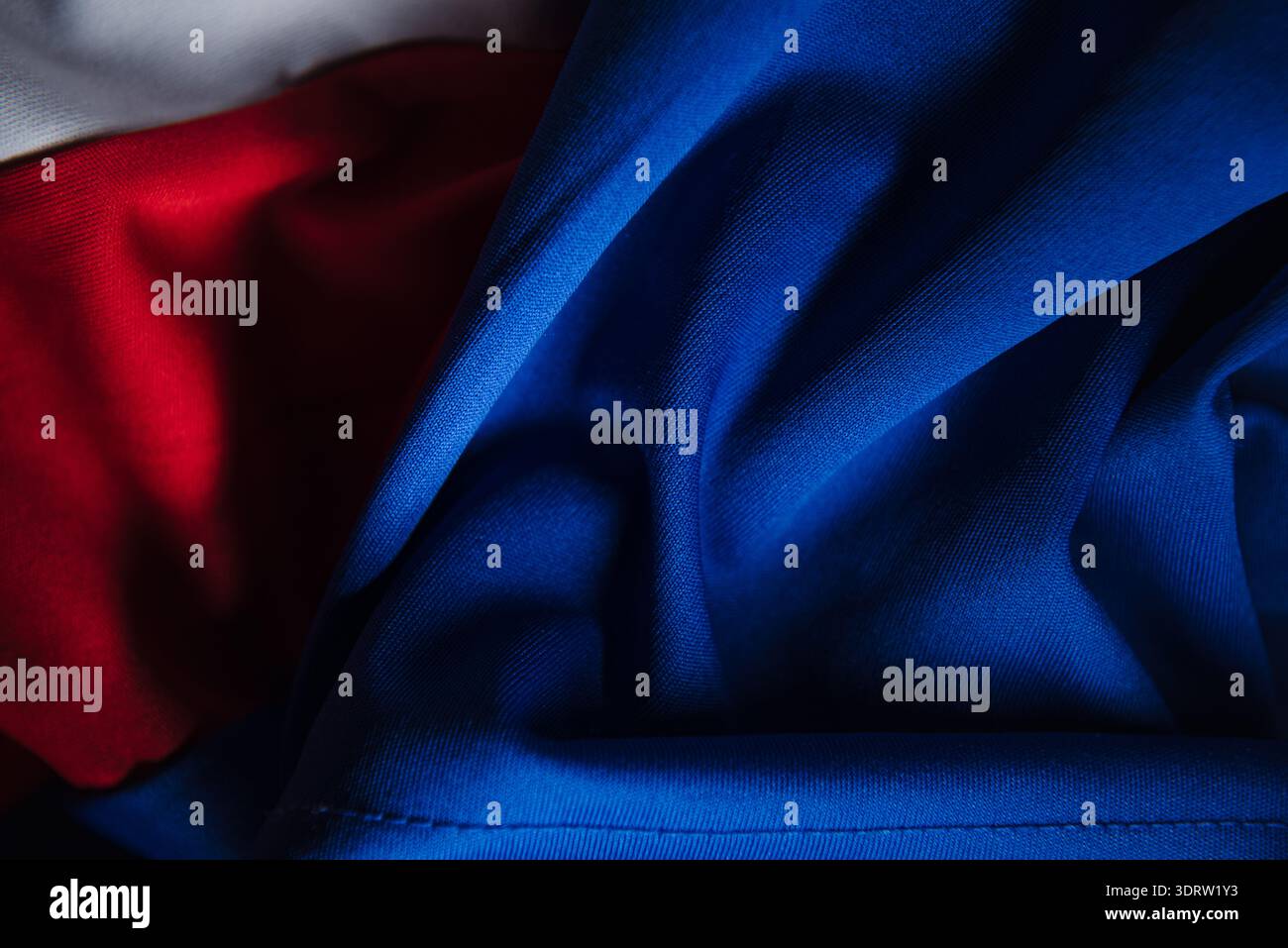 Dettagli in tessuto tecnico sportivo blu con cuciture sul fondo e sfondo in tessuto bianco rosso macro per un design di produzione di abbigliamento sportivo Foto Stock